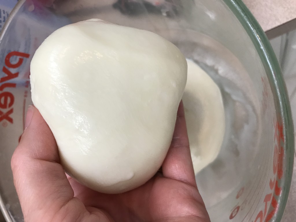 The fresh mozzarella ball is warmed, stretched and becomes a beautiful, smooth ball. It is ready to slice and serve.