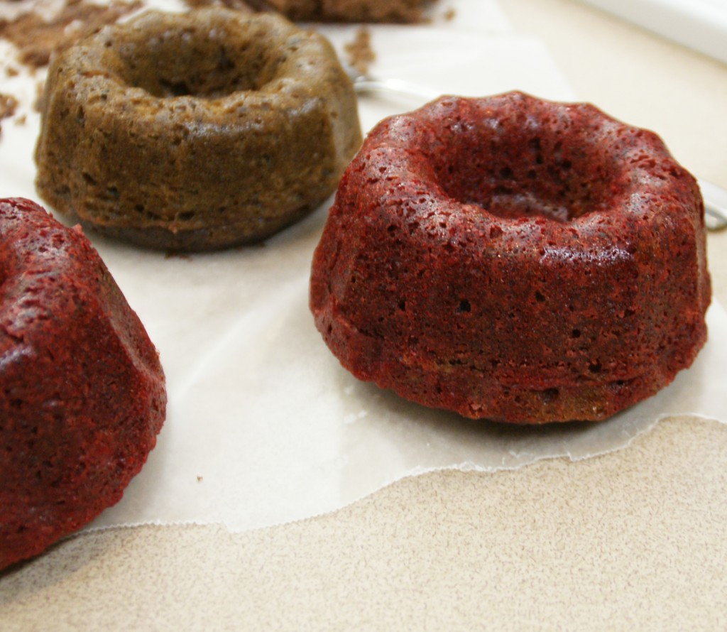 Bundt cake with beets is in the background. It turned brown as the batter reaches a high temperature and starts to set up. Chocolate batter with added beets and red food coloring is in the foreground. For the recognizable "red" found in red velvet cakes, a little food coloring helps the batter maintain its bright color even when heated.